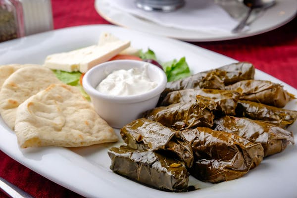 Dolmeh Entrée
Grape leaves individually stuffed with a mix of rice, onions, mint, spices, and olive oil. Served with sliced feta, olives , pita bread, and tzatziki.
_
